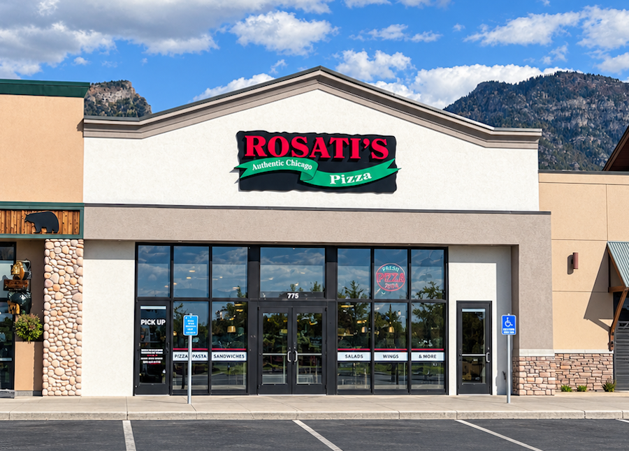 Rosati’s Pizza storefront in Orem, Utah, with the restaurant’s red and green logo above the entrance, parking lot in front, and mountains visible in the background.