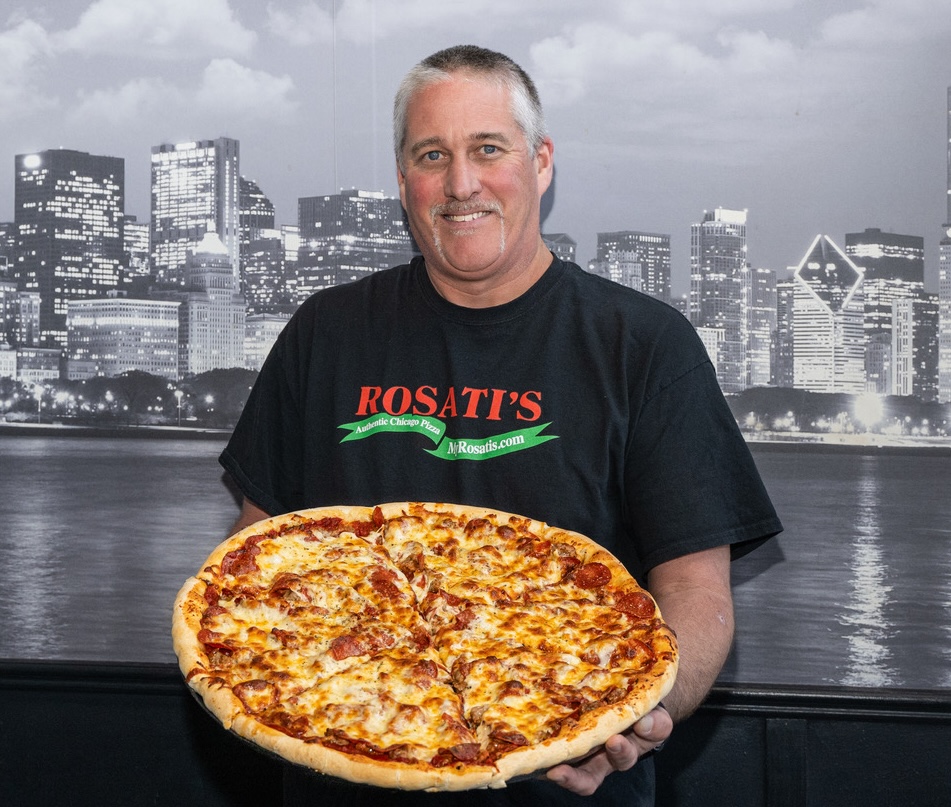 Rosati’s Pizza Sandwich store owner TJ Banning II holding a freshly baked pepperoni pizza.