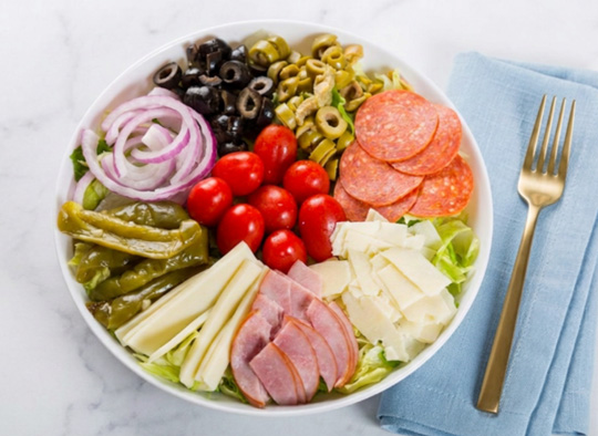 Antipasto salad with ham, pepperoni, cheeses, olives, tomatoes, peppers and red onion